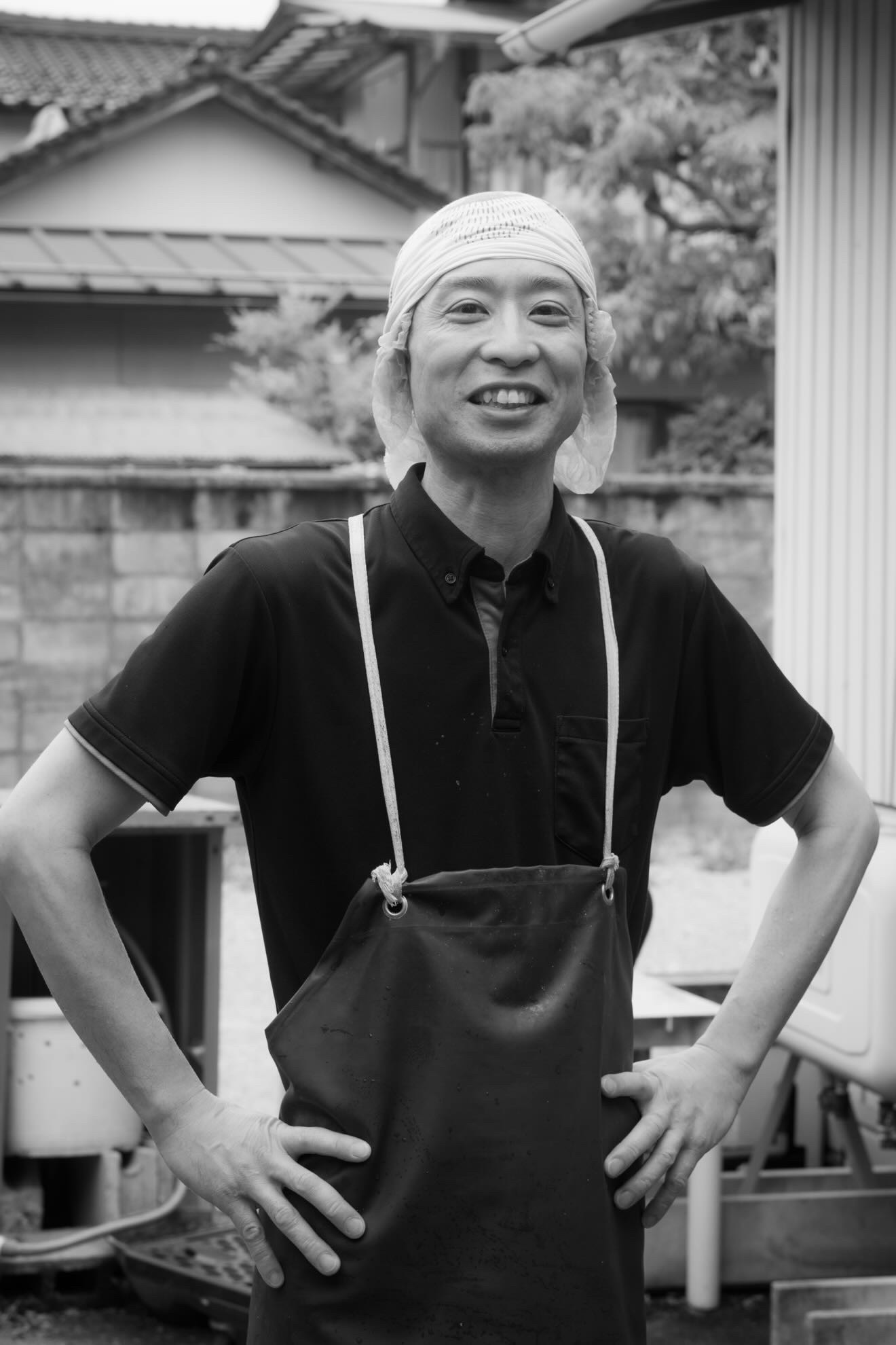 白い調理帽とエプロン姿で笑顔を見せる、白寿庵店主・鈴木尚